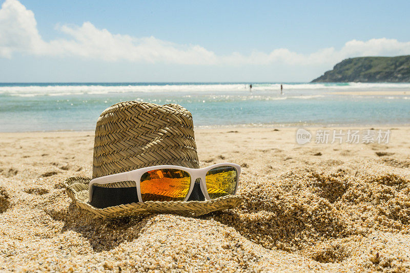 帽子和太阳镜在沙滩上，Pedn Vounder海滩，康沃尔。